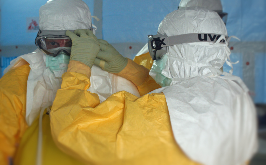 A person checking protective eyewear on a colleague.