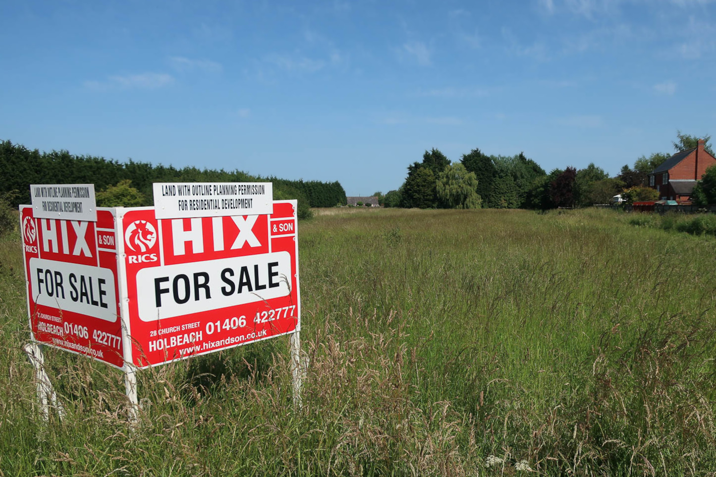A field with an estate agent's sign.