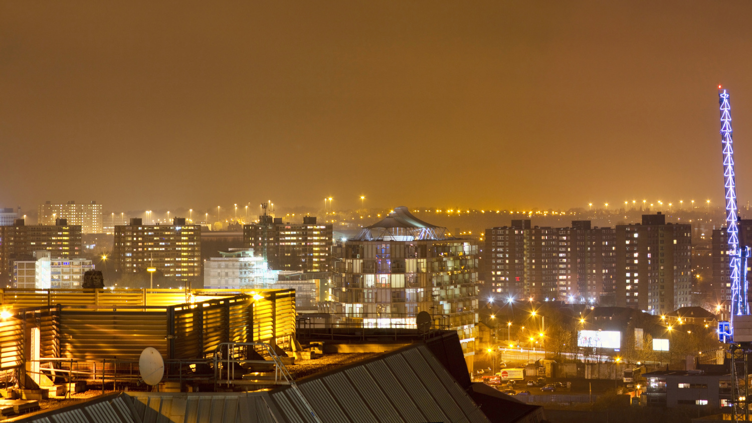 A view over a city bathed in artificial light.