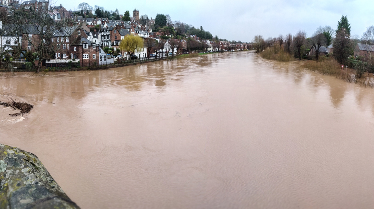 A river in flood  lined by buildings. 
