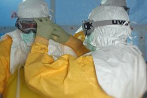 A person checking protective eyewear on a colleague.