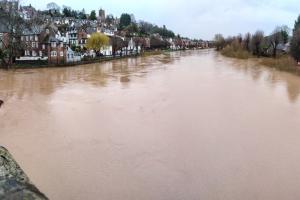 A river in flood  lined by buildings. 