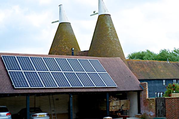 Solar panels on the roof of a building attached to an oast house.