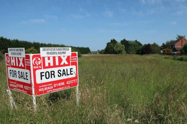 A field with an estate agent's sign.