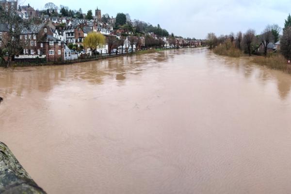 A river in flood  lined by buildings. 